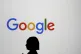 A woman walks by a giant screen with a logo at an event at t